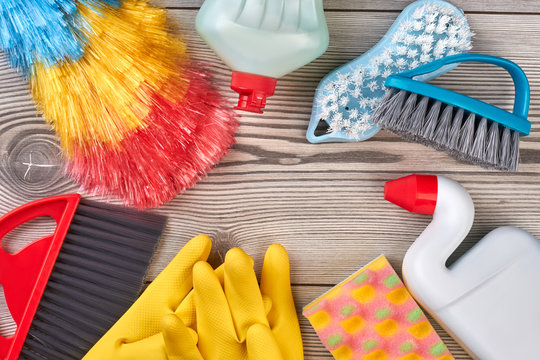 Close up frame from house cleaning supplies. Cleaning items and tools lying on textured grey floor background. Sponges and chemicals bottles.