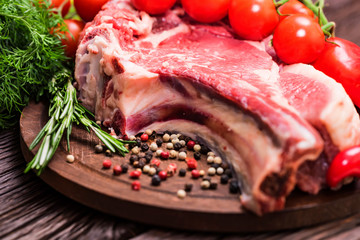 Raw beef steak with pepper, herbs and tomatoes