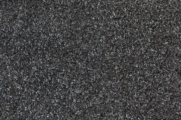 Close-up black  polyurethane foam texture. Rainbow film flares. Abstract black cellular background - obrazy, fototapety, plakaty