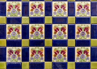 pattern of multicoloured tiles with painted embossed flower shapes