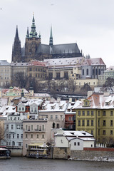 Snowy Prague Lesser Town with gothic Castle above River Vltava, Czech republic