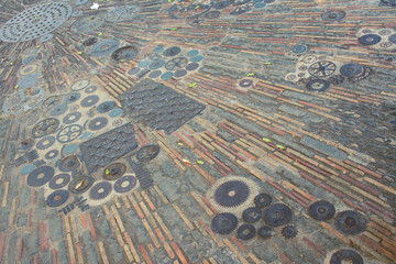 The surface of the floor of small parts. The pavement is made of automotive gears and pavers in Barcelona.