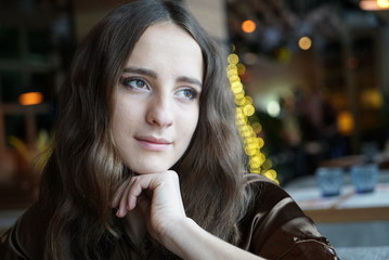 Obraz premium Cute young woman in a cafe looking through the window