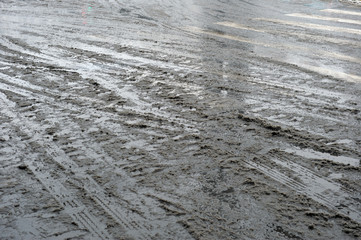 Car footprints in melted snow.