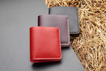 Set of three red brown and black wallet. Hand made leather man wallet . Multi colored. Leather craft.On cretive background .Top view