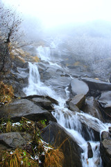 Cascade waterfall in mountains. Mountain river turns into waterfall