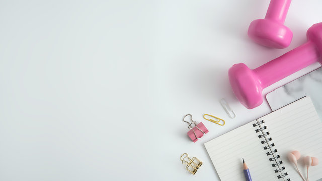 Styled Stock Photography Of Fitness Equipment Dumbbells Notepad Pencil And Earphone On White Background. Flat Lay.