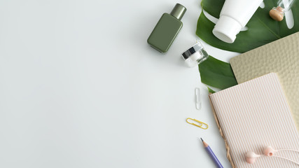 White cosmetic products and green leaves on white background. Natural beauty products for branding mock-up concept.