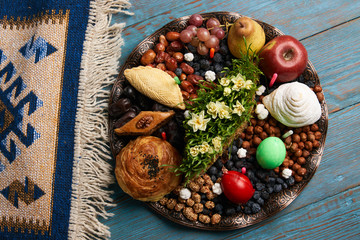 Novruz tray plate with Azerbaijan national pastry pakhlava , shekerbura, gogal and dry fruit snack on rustic table  background. spring new year celebration top view