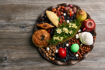 Novruz tray plate with Azerbaijan national pastry pakhlava , shekerbura, gogal and dry fruit snack on rustic table  background. spring new year celebration top view