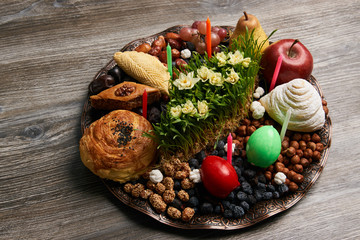 Novruz tray plate with Azerbaijan national pastry pakhlava , shekerbura, gogal and dry fruit snack on rustic table  background. spring new year celebration top view