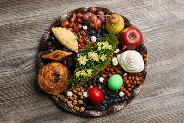 Novruz tray plate with Azerbaijan national pastry pakhlava , shekerbura, gogal and dry fruit snack on rustic table  background. spring new year celebration top view