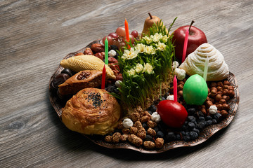 Novruz tray plate with Azerbaijan national pastry pakhlava , shekerbura, gogal and dry fruit snack on rustic table  background. spring new year celebration top view