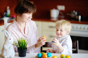 Obraz na płótnie Canvas Beautiful woman and her cute son or grandson playing with easter egg on Easter day