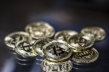 Bitcoin coins on a dark background with reflection