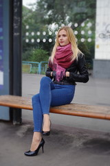 Girl is sitting at a public transport stop