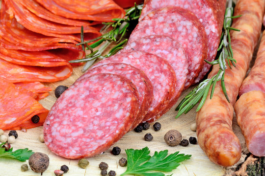 Sliced of chorizo, salami and sausages with spices on table