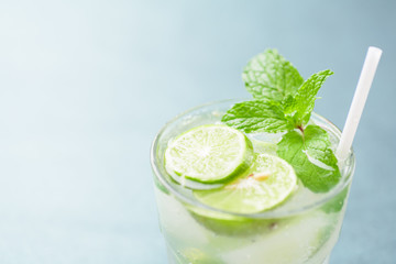Glass of iced lemonade soda with slice lime and mint leaves, cold drink in summer