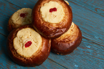 Round Russian scones with cottage cheese - vatrushka on rustic wooden table background, top view. Traditional Russian baking.