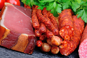 Sausages with salami and prosciutto crudo on table