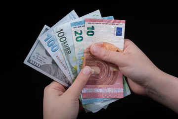 Hand holding American dollar  isolated on black background