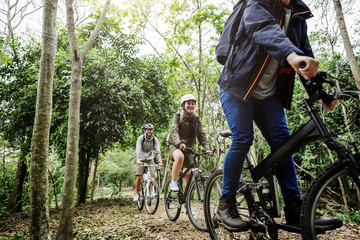 Naklejka premium Group of friends ride mountain bike in the forest together