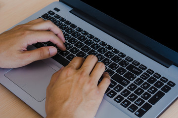 Close up hands of man typing the charectorwith laptop thai keyboard.