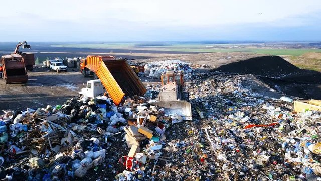 City Dump. The Bulldozer Compacts the Garbage on the Landfill. Wastes of Human Life