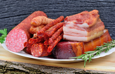 Delicious smoked bacon,sausages, prosciutto crudo and salami on plate