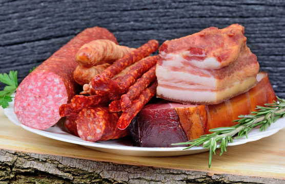 Delicious smoked bacon,sausages, prosciutto crudo and salami on plate