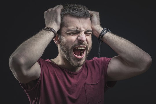 Enraged Furious Young Man Screaming In Anger, Pulling His Hair Out