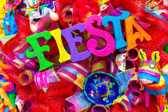 The word 'fiesta' written in colorful foam letters on multicolored mash decorated with glitter and small sombrero