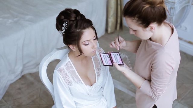 Wedding makeup artist making a make up for bride