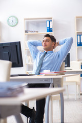 Handsome businessman employee sitting at his desk in office