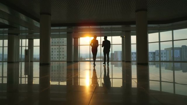 The business man and a woman walking in the modern office. slow motion