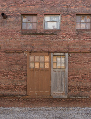 Fototapeta na wymiar old sliding barn doors on outside brick wall of old factory