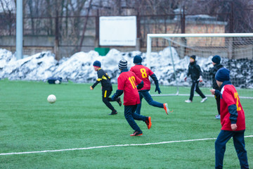 Obraz premium boys play football on the winter stadium