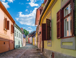 Fototapeta na wymiar Beautiful Transylvanian street on a sunny summer day in Sighisoara, Romania.