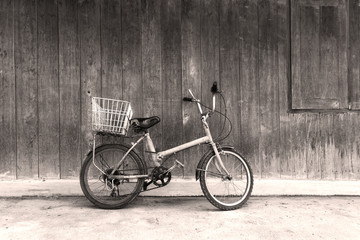 Fototapeta na wymiar Black and white old bicycle leaning against wall