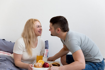 Obraz na płótnie Canvas Couple enjoying breakfast in bed