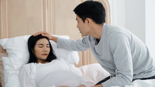 Young husband check digital thermometer to his wife pregnant