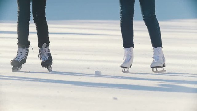 Two teen girlfriends learning to skate and having fun - legs close up