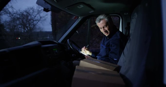 4K Delivery driver with negative attitude sitting in van checking parcels for delivery