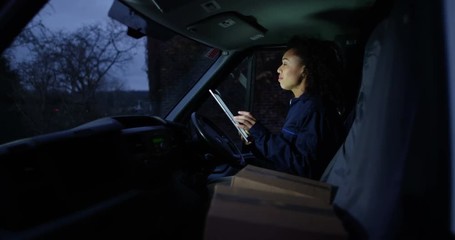 4K Happy female delivery driver on early or late shift dancing along to music in van. Slow motion.