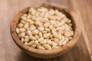 pine nuts in wood bowl on table