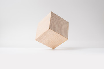 Design concept - abstract geometric real wooden cube with surreal layout on white floor background and it's not 3D render