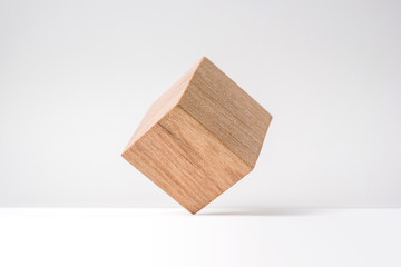 Design concept - abstract geometric real wooden cube with surreal layout on white floor background and it's not 3D render