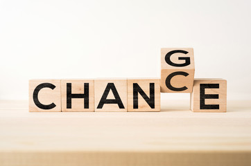 Business and design concept - surreal abstract geometric floating wooden cube with word " CHANGE & CHANCE " concept on wood floor and white background