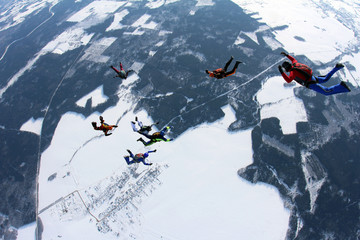 Skydivers are in the winter sky.