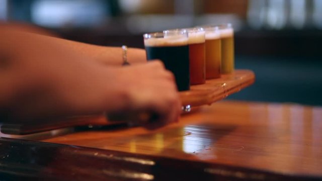Waiter picks up a palette of freshly poured beer from a bar with a rustic setting
